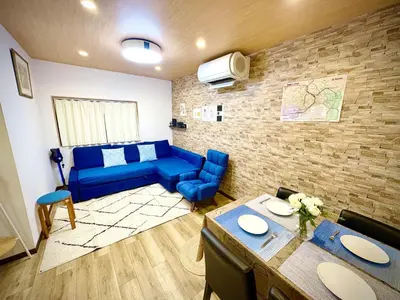 a living room with a blue couch and a table at Pine House 6 minutes by train to Ikebukuro 11 minutes to Shinjuku Convenient access to Ueno by train in Tokyo