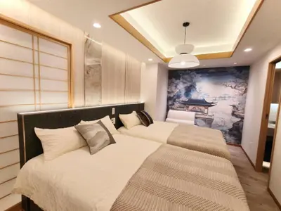 two beds in a bedroom with a painting on the wall at A2 Shinjuku JR St 8 mins 3 bedrooms and 1 living room 2bathrooms 2toilets Max 12P Direct to Shinjuku Ueno Ginza Shibuya Ikebukuro Yoyogi Shinagawa \u65b0\u5bbf\u533a \u9ad8\u7530\u9a6c\u573a\u8f66\u7ad98\u5206\u949f 3\u5ba41\u53852\u6d74\u5ba42\u536b\u751f\u95f4 \u6700\u592712\u4eba in Tokyo