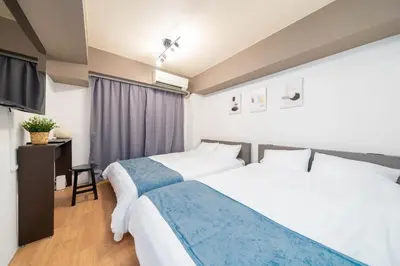 a hotel room with two beds and a television at Newly opened! 4 minutes on foot from Shin-Okubo station in Tokyo
