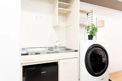 a white kitchen with a dishwasher and a sink at Newly opened! 4 minutes on foot from Shin-Okubo station in Tokyo