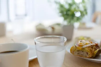 a glass of water sitting next to a plate of food at KOU Jiyugaoka 101 in Tokyo