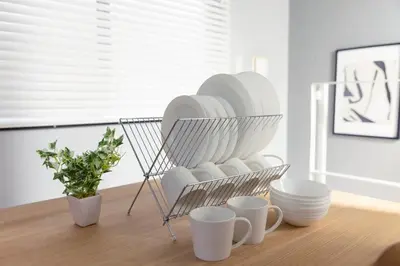 a plate rack with plates and cups on a table at KOU Jiyugaoka 101 in Tokyo