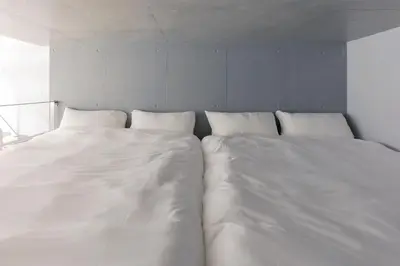 two large white beds sitting next to each other at KOU Jiyugaoka 101 in Tokyo