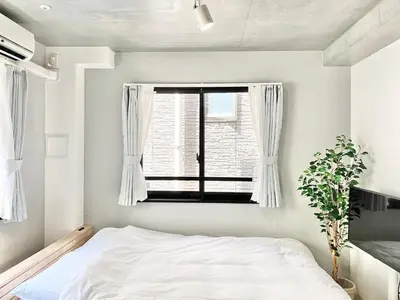 a bedroom with a bed and a window at KOU Jiyugaoka 202 in Tokyo
