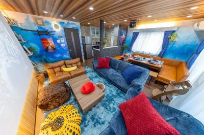 a living room with a blue couch and a table at 3 minutes from Sangenjaya 90square meters 50square meters rooftop 3LDK Relaxing Tokyo stay with rooftop, jacuzzi projector in Tokyo