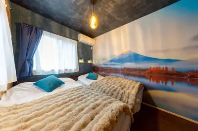 two beds in a bedroom with a painting on the wall at 3 minutes from Sangenjaya 90square meters 50square meters rooftop 3LDK Relaxing Tokyo stay with rooftop, jacuzzi projector in Tokyo