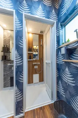 a bathroom with a shower with a blue wall at 3 minutes from Sangenjaya 90square meters 50square meters rooftop 3LDK Relaxing Tokyo stay with rooftop, jacuzzi projector in Tokyo