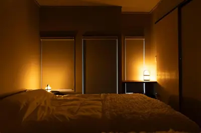 a dark room with a bed and two lamps at KOU Ikebukuro in Tokyo