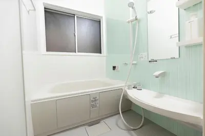 a bathroom with a tub and a sink and a mirror at KOU Ikebukuro in Tokyo