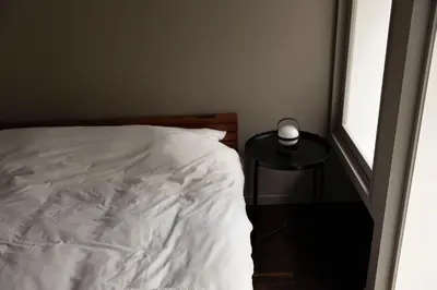 a bedroom with a white bed and a small table at KOU Ikebukuro in Tokyo