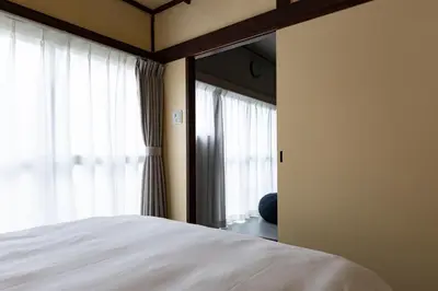 a bedroom with a white bed and a mirror at KOU Ikebukuro in Tokyo