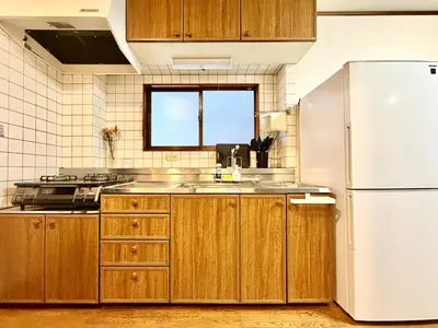 a kitchen with wooden cabinets and a white refrigerator at Ninja Tokyo Hideaway Higashi-Shinkoiwa in Tokyo