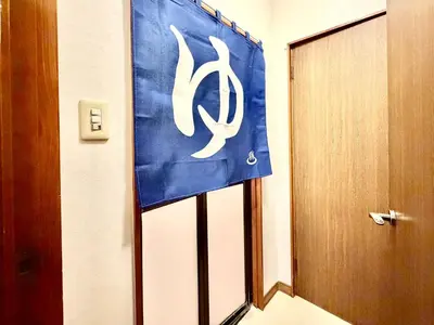 a door with a blue and white sign in a room at Ninja Tokyo Hideaway Higashi-Shinkoiwa in Tokyo