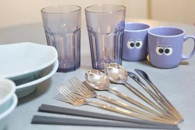 a table with utensils and cups and forks and spoons at The underz suite residence Ikebukuro by Tranova in Tokyo