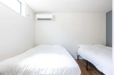 two beds in a white room with a window at TRUSS 2nd in Tokyo