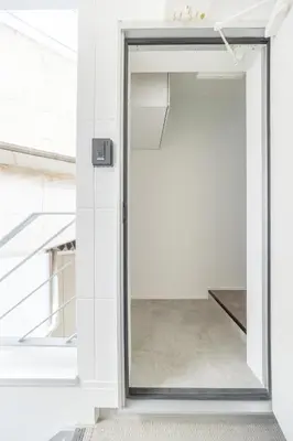 a glass door leading into a room with white walls at TRUSS 2nd in Tokyo