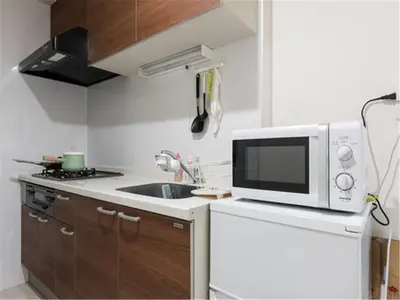 a small kitchen with a microwave and a sink at A Stay in Shinjuku in Tokyo