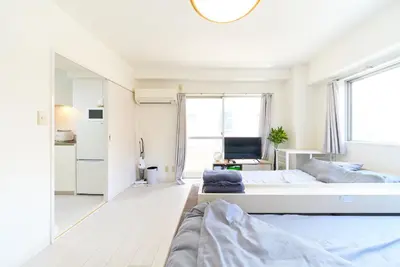 a bedroom with two beds and a large window at Maison Junes 21 in Tokyo