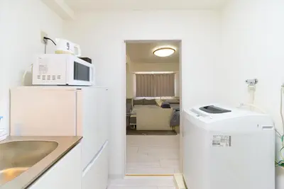 a kitchen with a microwave and a refrigerator at Maison Junes 21 in Tokyo