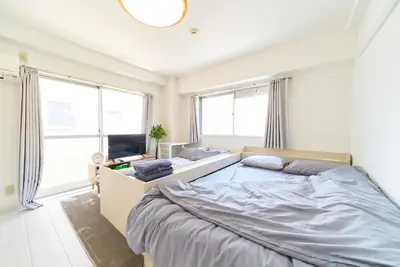 a bedroom with a large bed and a tv at Maison Junes 21 in Tokyo