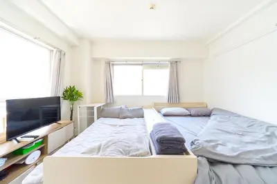 a bedroom with a bed and a flat screen tv at Maison Junes 21 in Tokyo