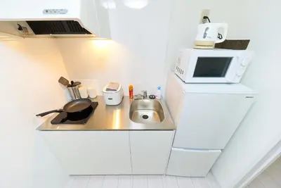 a small kitchen with a sink and a microwave at Maison Junes 21 in Tokyo