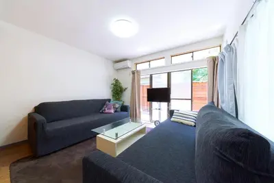a living room with a couch and a table at Kita-Shinjuku INN House in Tokyo