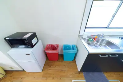 a small kitchen with a sink and a microwave at Kita-Shinjuku INN House in Tokyo