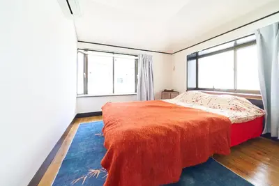 a bedroom with a large bed and two windows at Kita-Shinjuku INN House in Tokyo