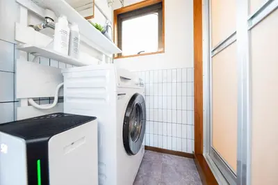 a small laundry room with a washer and dryer at LiveStay HIROO - 1BR and Cozy Living Area, 5th floor NO elevator, 34m2, 1-3 ppl, Hiroo Area, from Stn 10 min to Shibuya in Tokyo