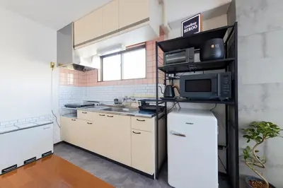 a small kitchen with a microwave and a refrigerator at LiveStay HIROO - 1BR and Cozy Living Area, 5th floor NO elevator, 34m2, 1-3 ppl, Hiroo Area, from Stn 10 min to Shibuya in Tokyo