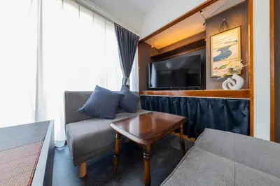 a living room with a couch and a tv and a table at LiveStay HIROO - 1BR and Cozy Living Area, 5th floor NO elevator, 34m2, 1-3 ppl, Hiroo Area, from Stn 10 min to Shibuya in Tokyo