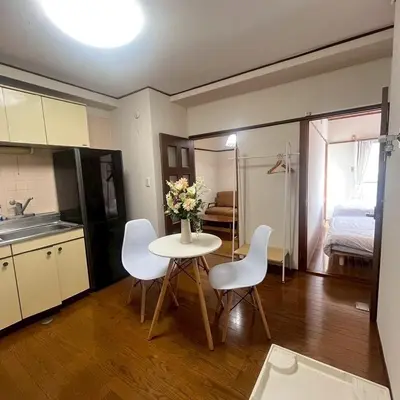 a kitchen with a table and white chairs and a room at \u83ef -Hana- in Tokyo