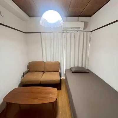 a small room with a bed and a chair at \u83ef -Hana- in Tokyo
