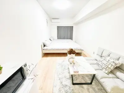 a white living room with a couch and a bed at Ikebukuro Cozy \u30cf\u30a6\u30b95 in Tokyo