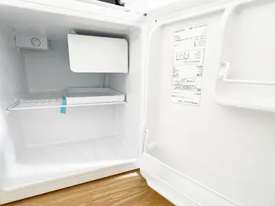 an empty refrigerator with its door open on a wooden floor at Ikebukuro Cozy \u30cf\u30a6\u30b95 in Tokyo