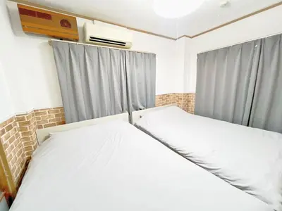 a bedroom with two white beds and curtains at Nogata Relaxing Home C1 in Tokyo