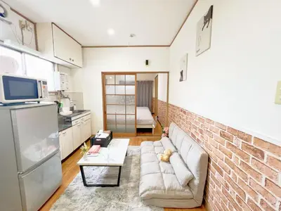 a living room with a couch and a brick wall at Nogata Relaxing Home C1 in Tokyo