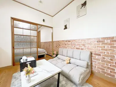 a living room with a couch and a brick wall at Nogata Relaxing Home C1 in Tokyo