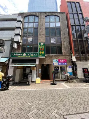 a building on a street with a person sitting on a bench at \u8d64\u5742\u30db\u30b9\u30c6\u30eb in Tokyo