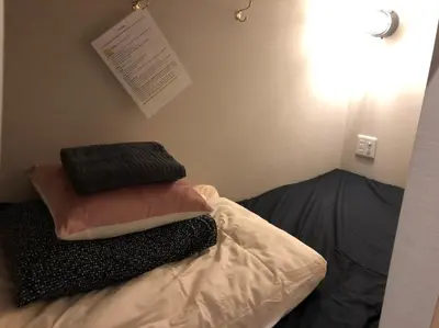 a bed with three pillows on top of it at \u795e\u7530\u5927\u624b\u753a\u30db\u30b9\u30c6\u30eb in Tokyo
