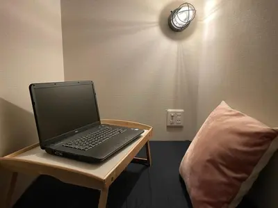 a laptop computer sitting on a table next to a pillow at \u795e\u7530\u5927\u624b\u753a\u30db\u30b9\u30c6\u30eb in Tokyo