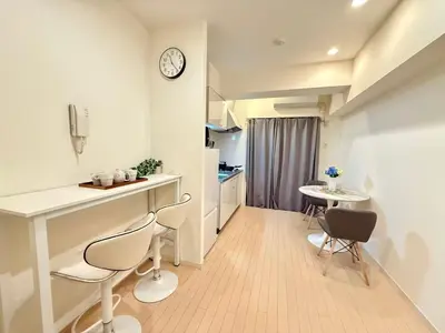 a kitchen with a table and chairs and a clock on a wall at Ikebukuro 2Room D3 in Tokyo