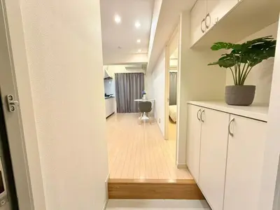 a hallway leading to a kitchen with a potted plant at Ikebukuro 2Room D3 in Tokyo