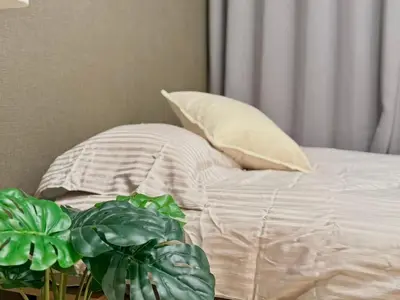 a bed with white sheets and a pillow and a plant at Ikebukuro 2Room D3 in Tokyo