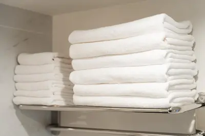 a stack of towels on a shelf in a bathroom at Brand New Luxury Suite 7 min to Omotesando 2 min to Shibuya in Tokyo