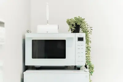 a microwave sitting on top of a white shelf with a plant at Brand New Luxury Suite 7 min to Omotesando 2 min to Shibuya in Tokyo