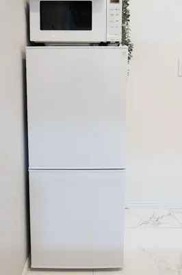 a microwave on top of a white refrigerator at Brand New Luxury Suite 7 min to Omotesando 2 min to Shibuya in Tokyo