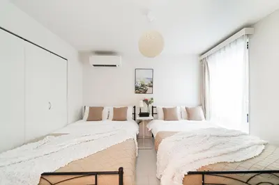 two beds in a bedroom with white walls at Brand New Luxury Suite 7 min to Omotesando 2 min to Shibuya in Tokyo