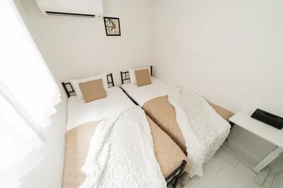 two beds in a room with white walls at Brand New Luxury Suite 7 min to Omotesando 2 min to Shibuya in Tokyo